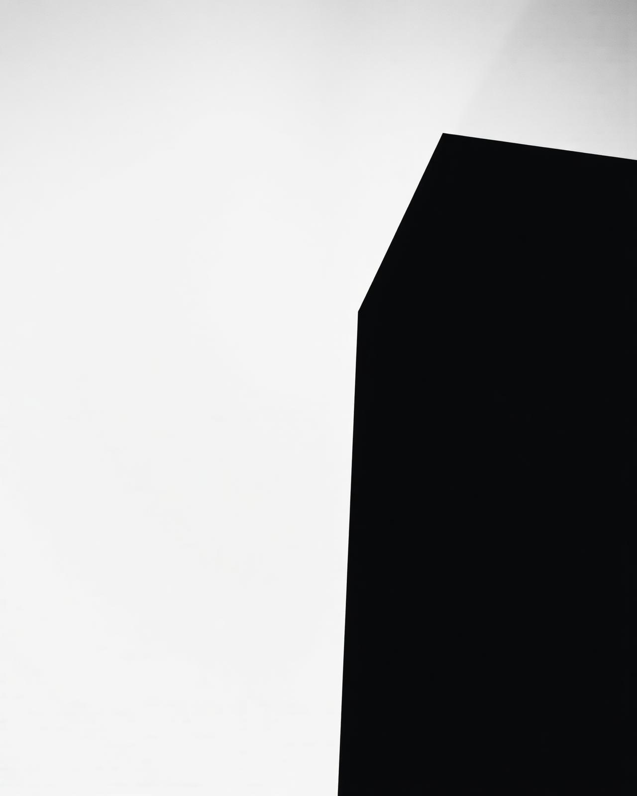 Minimalist black architectural form against pale sky