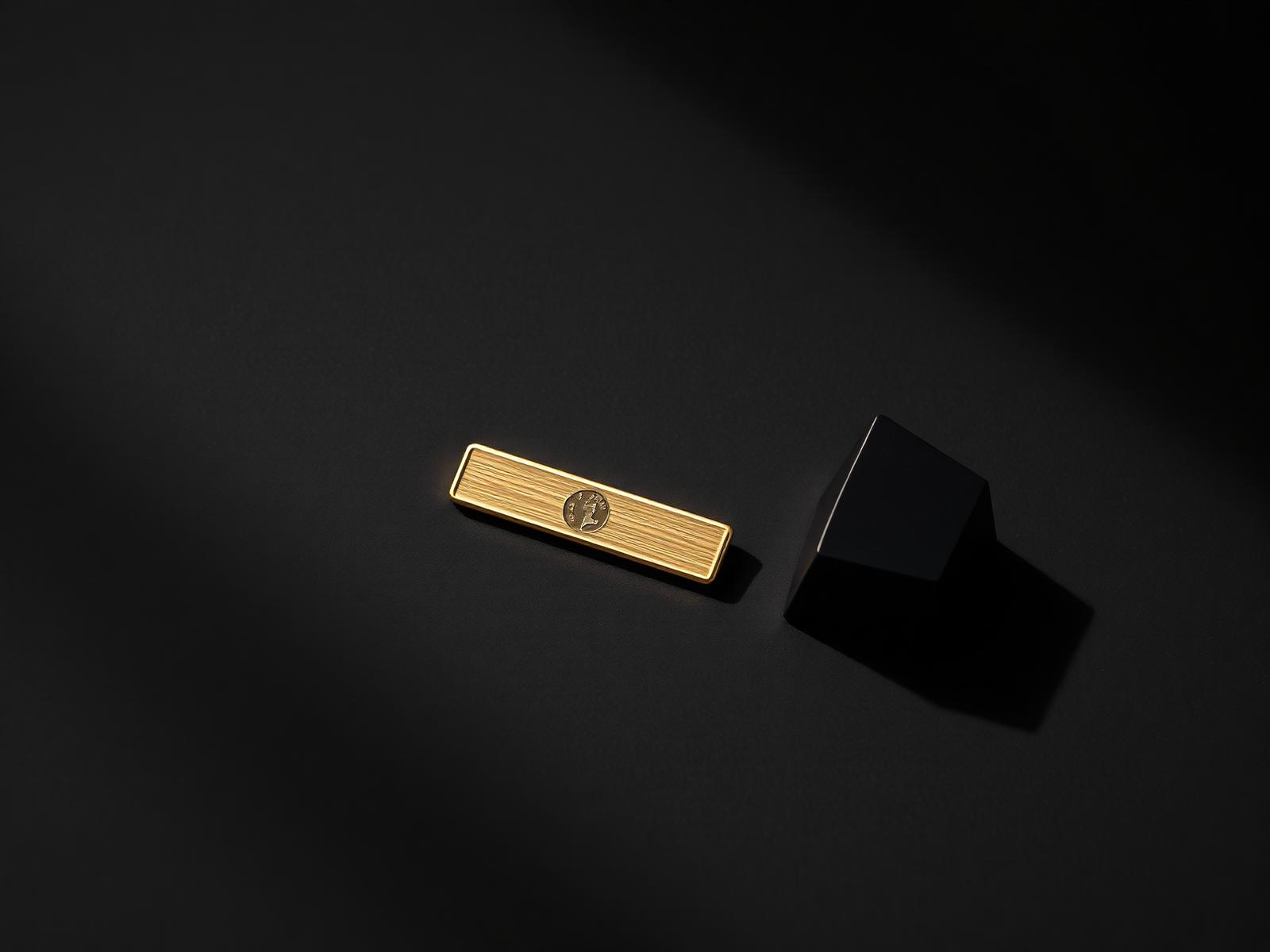 A gold bar and a black geometric form lit against deep shadow